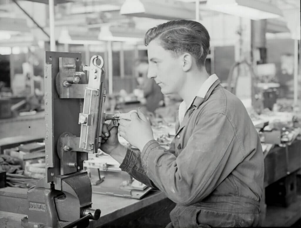 man in gray jacket holding a machine