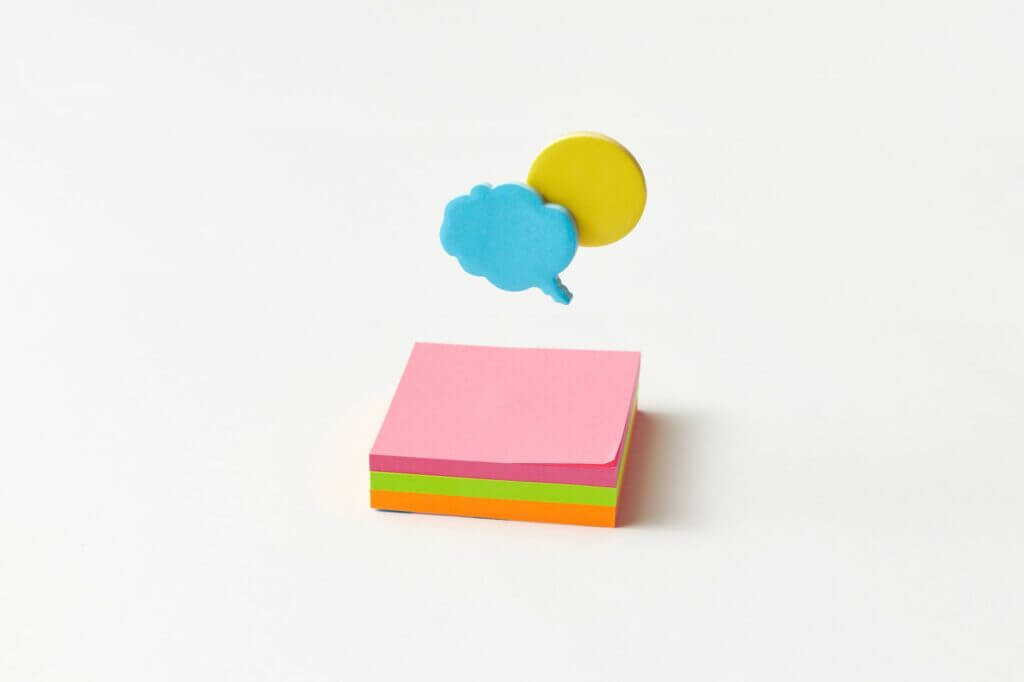 a cloud and round speech bubbles over a pad of sticky notes