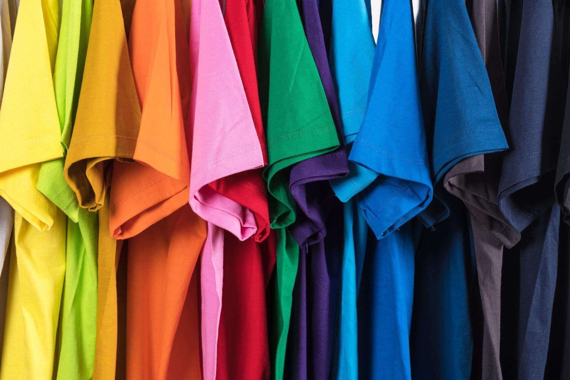 set of multicolored t shirts hanging in row
