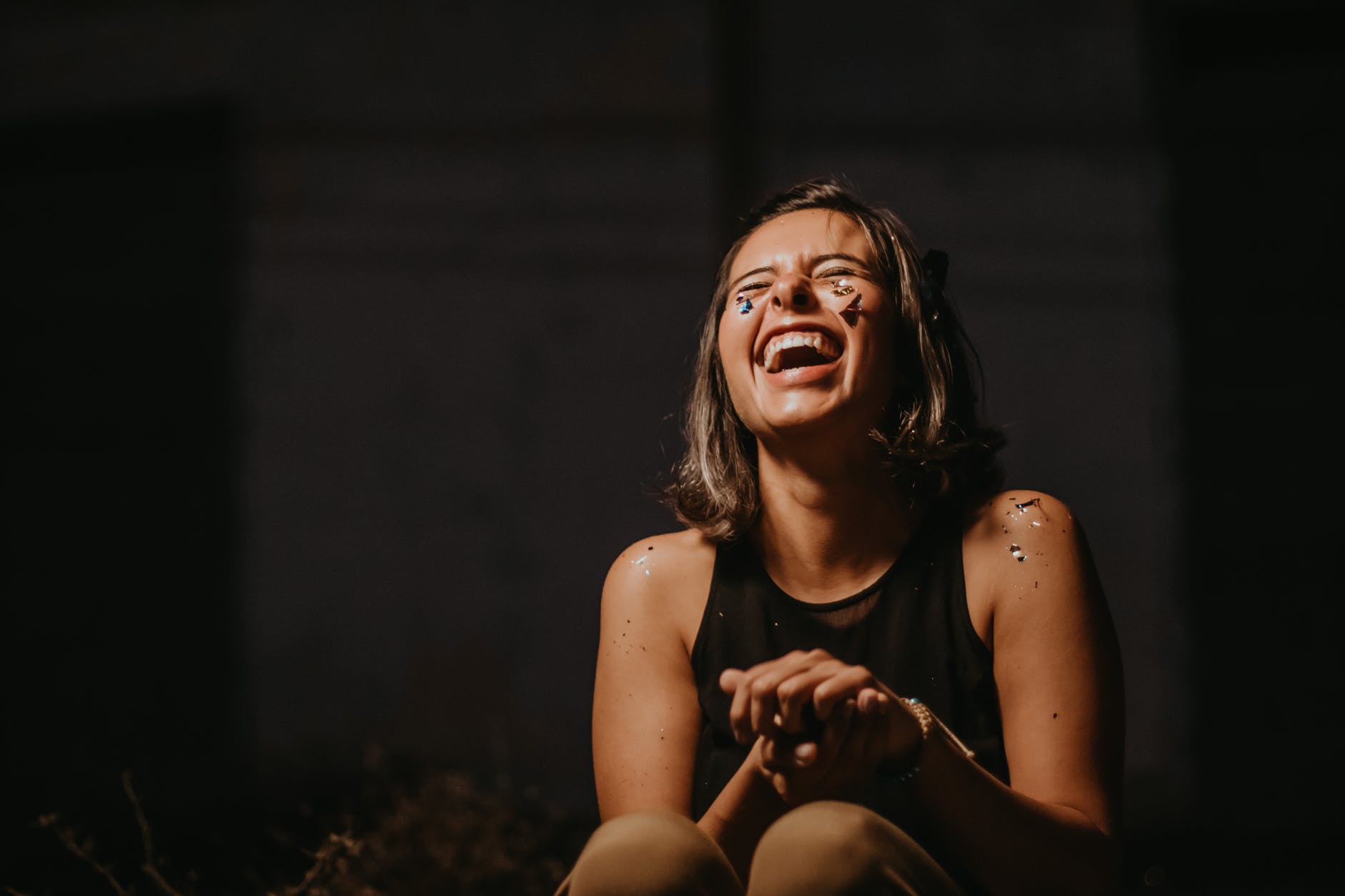 photo of a woman laughing wearing black top