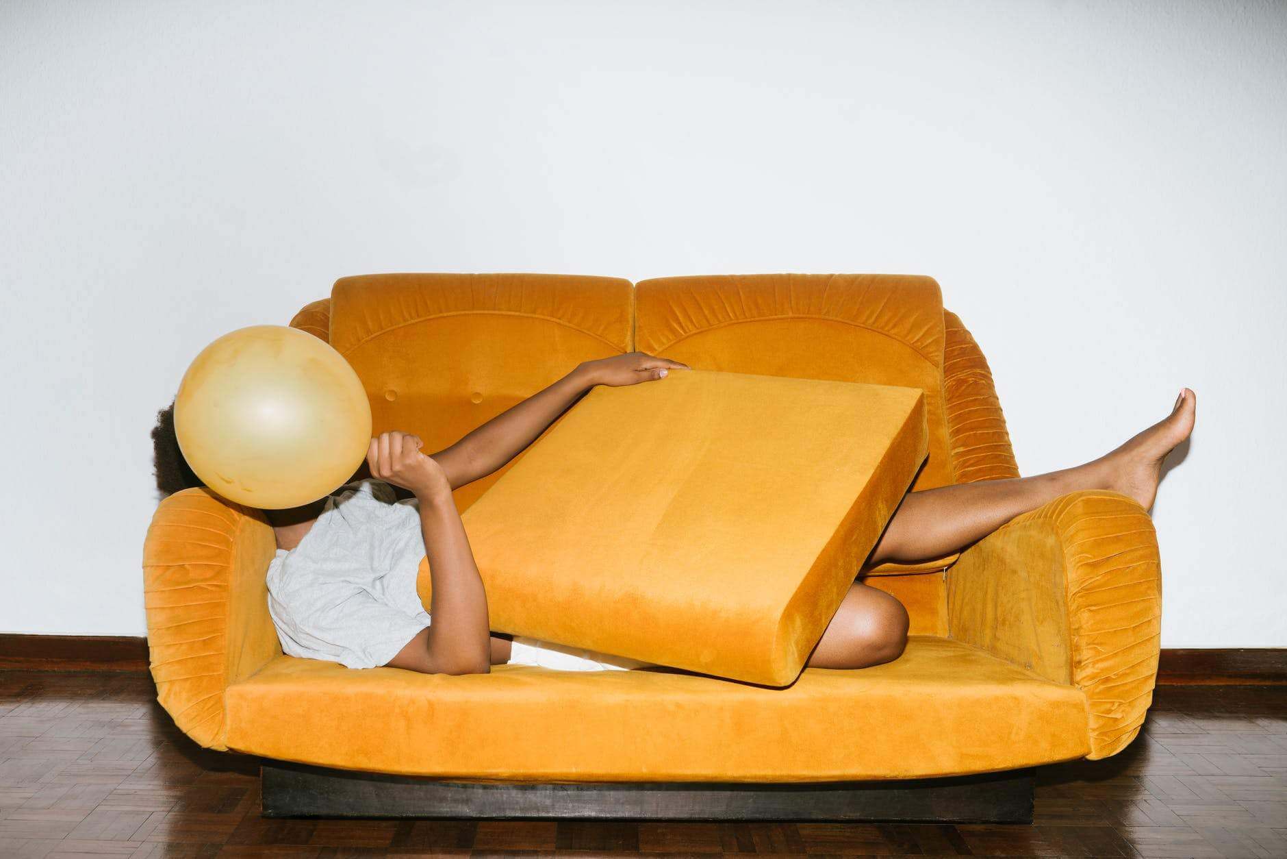 person lying on orange sofa