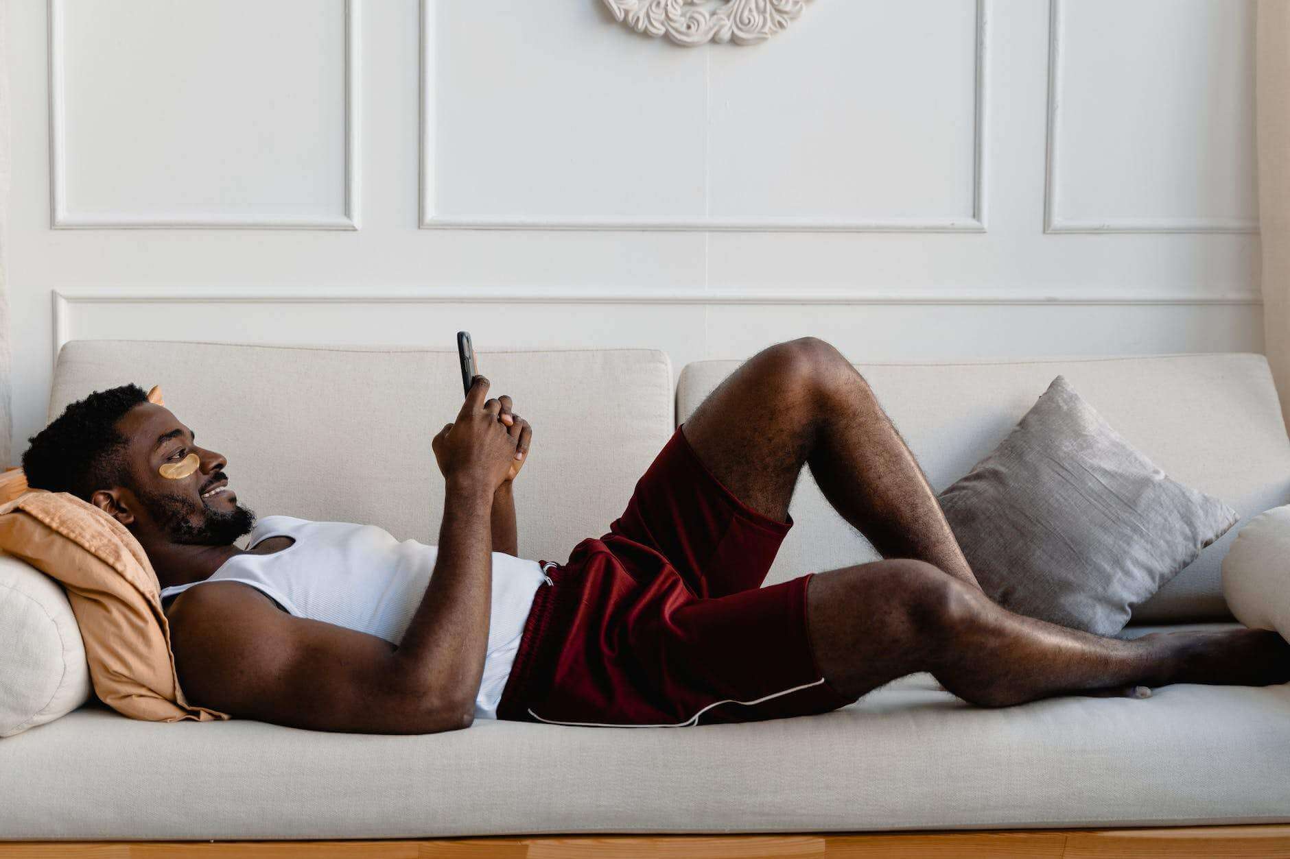 man relaxing on the sofa while using cellphone
