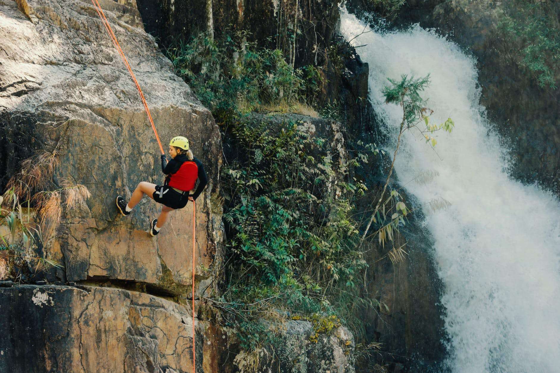 woman rocking climbing near waterfalls