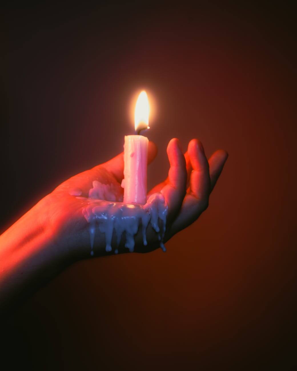 melting wax candle in hand